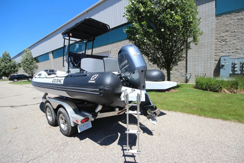 Slide: The Image of 2020 Zodiac Open 6.5 boat on trailer with Yamaha engine, parked outdoors. - 7