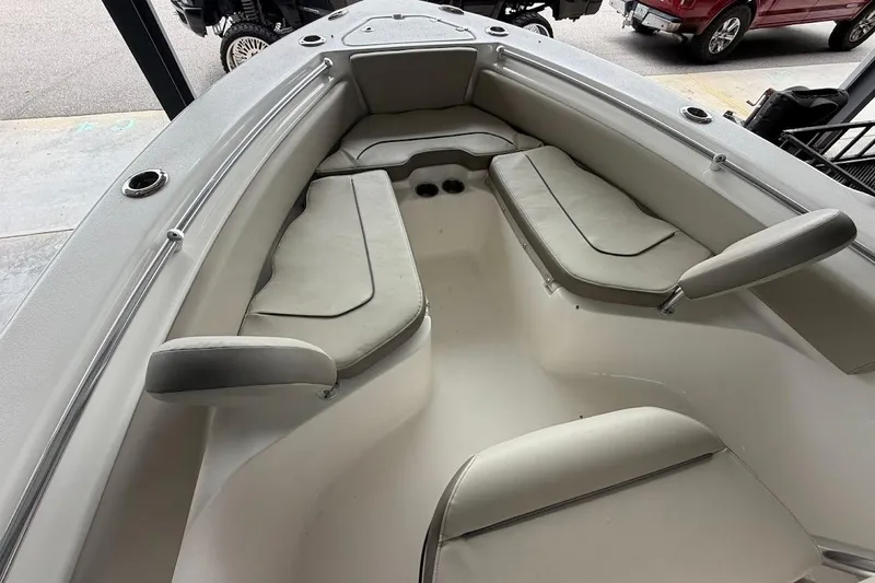 Slide: The Image of 2024 Key West 219 FS boat interior with cushioned seating and cup holders. - 11