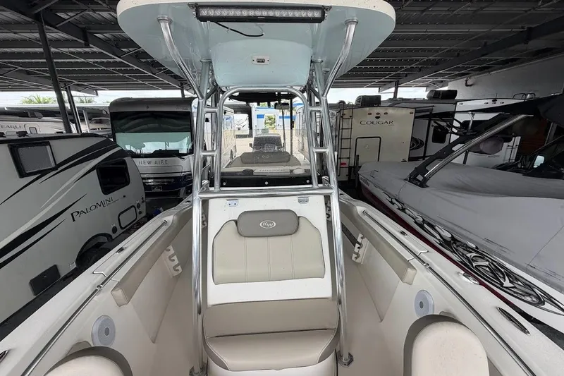 Slide: The Image of 2024 Key West 219 FS boat interior with seating and canopy, surrounded by RVs. - 12