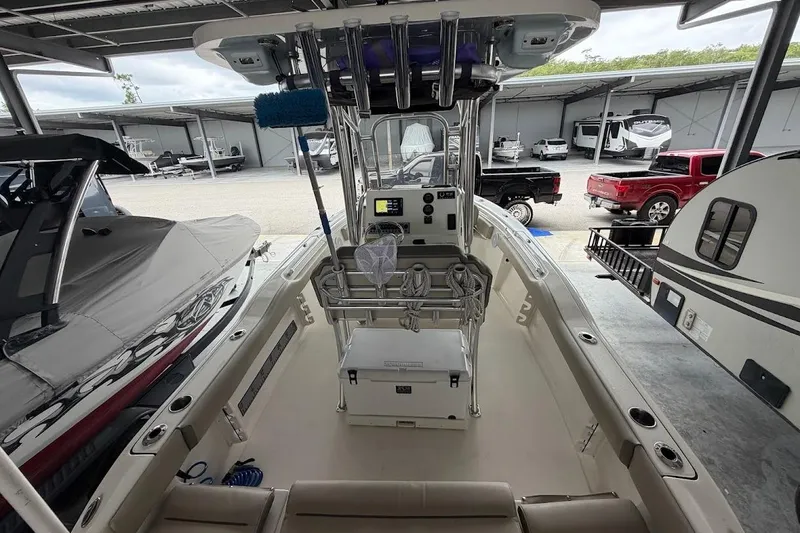 Slide: The Image of 2024 Key West 219 FS boat interior, featuring console and seating, in a showroom setting. - 14