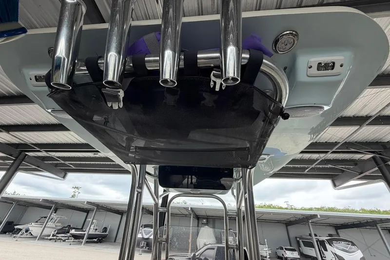 Slide: The Image of 2024 Key West 219 FS boat with rod holders and storage net under a canopy. - 15