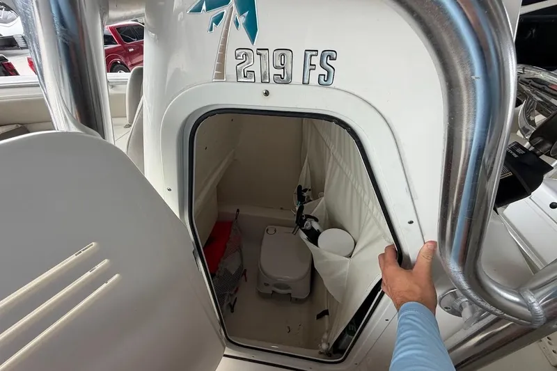 Slide: The Image of 2024 Key West 219 FS boat interior with storage compartment and portable toilet. - 17