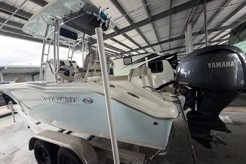 Slide: The Image of 2024 Key West 219 FS boat with Yamaha engine in a covered storage area. - 2