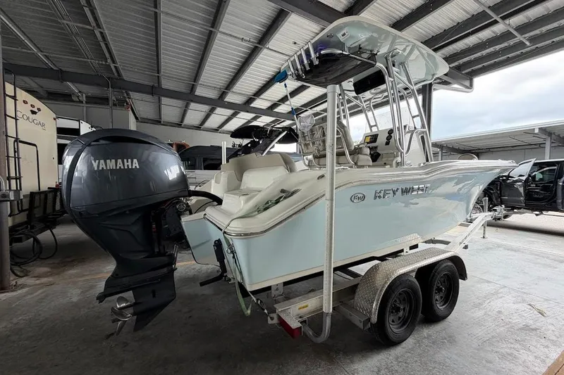 Slide: The Image of 2024 Key West 219 FS boat on trailer with Yamaha outboard motor in covered storage. - 3