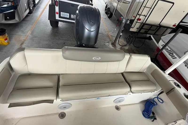 Slide: The Image of 2024 Key West 219 FS boat interior with beige seating and motor in storage. - 6