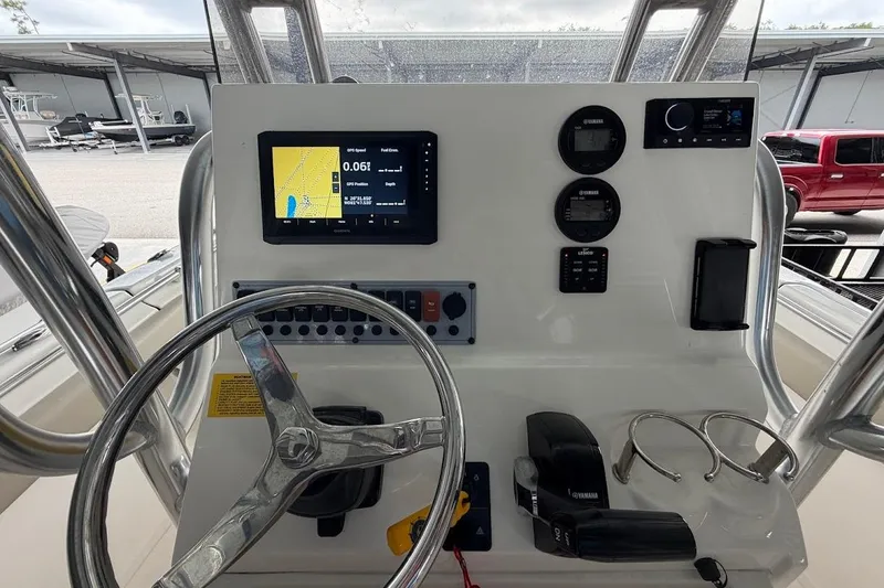 Slide: The Image of 2024 Key West 219 FS boat dashboard with GPS, controls, and steering wheel. - 9