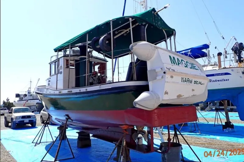 Slide: The Image of 1961 William Garden Custom boat on stands, with inflatable dinghy, in a boatyard setting. - 2