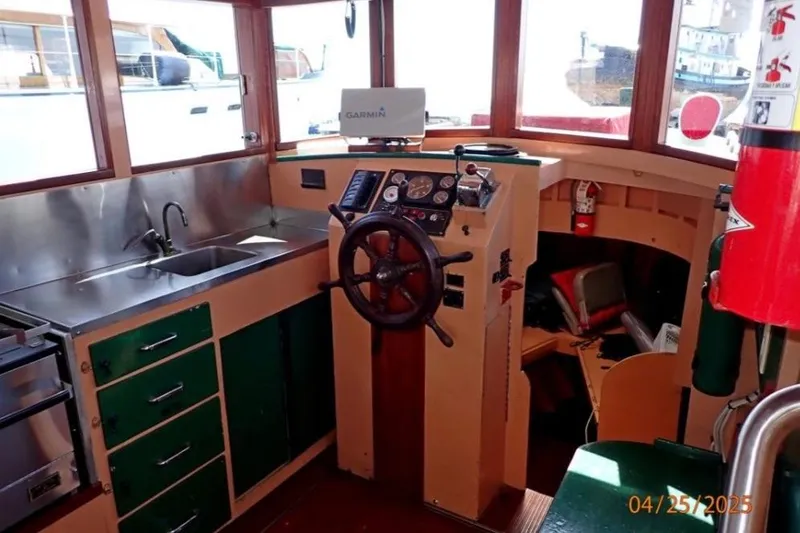 Slide: The Image of 1961 William Garden Custom boat interior with steering wheel, sink, and navigation equipment. - 4