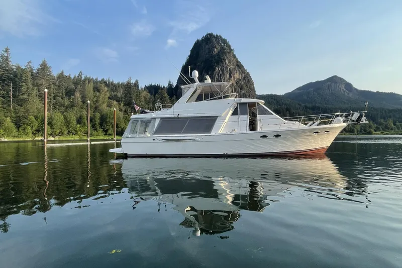 The Image of 2008 Meridian 490 Pilothouse yacht on serene lake with mountainous backdrop. - 0