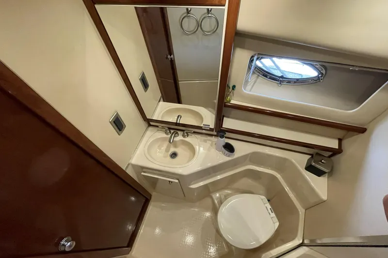 Slide: The Image of Bathroom interior of 2008 Meridian 490 Pilothouse yacht, featuring sink, toilet, and porthole window. - 18