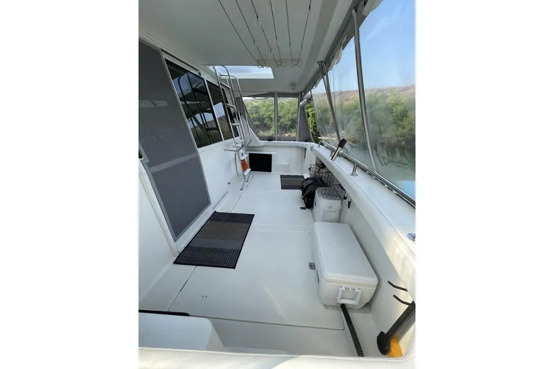 Slide: The Image of 2008 Meridian 490 Pilothouse boat interior with seating and storage, featuring large windows. - 42