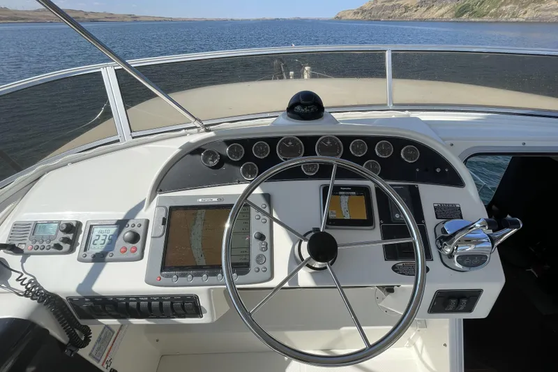 Slide: The Image of 2008 Meridian 490 Pilothouse helm with navigation instruments, steering wheel, and throttle controls. - 57