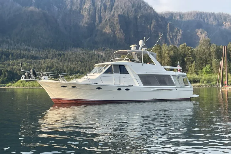 Slide: The Image of 2008 Meridian 490 Pilothouse yacht on serene water with forested mountain backdrop. - 68
