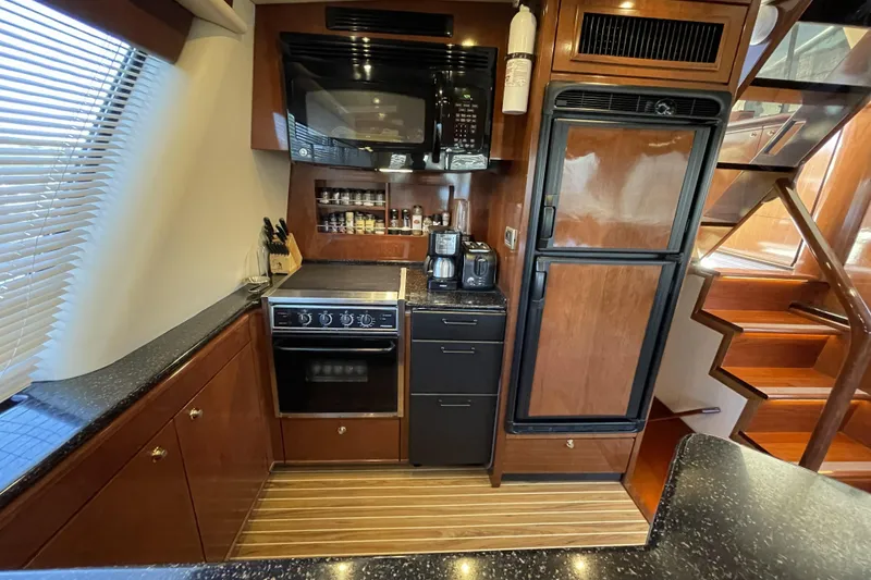 Slide: The Image of Luxurious kitchen in 2008 Meridian 490 Pilothouse yacht with modern appliances and wooden cabinetry. - 7