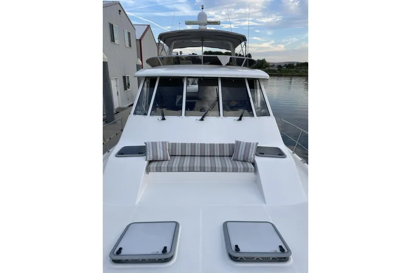 Slide: The Image of 2008 Meridian 490 Pilothouse yacht with striped cushions, docked by waterfront buildings. - 70