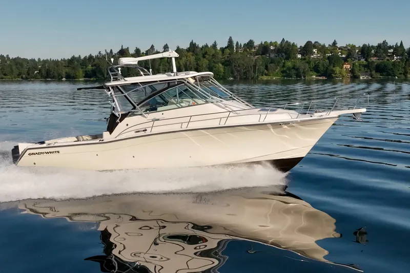 Slide: The Image of 2006 Grady-White Express 360 cruising on a serene lake with lush green shoreline. - 10