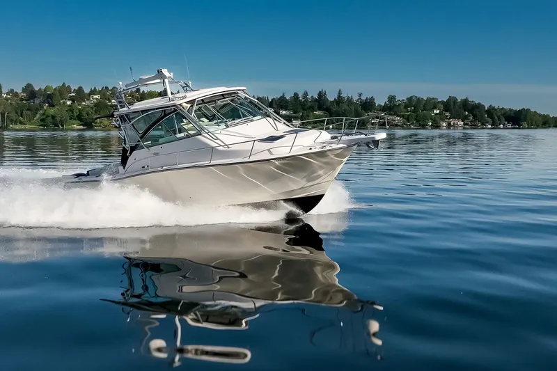 Slide: The Image of 2006 Grady-White Express 360 boat cruising on a serene lake under a clear blue sky. - 12