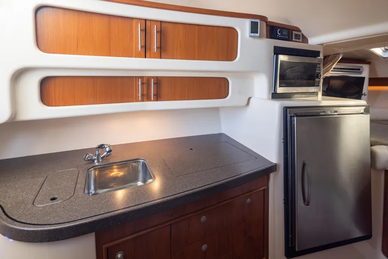 Slide: The Image of 2006 Grady-White Express 360 boat interior with kitchenette, sink, and stainless steel appliances. - 27