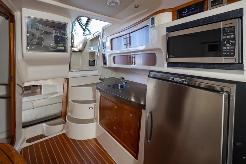 Slide: The Image of Interior of 2006 Grady-White Express 360 boat with kitchen amenities and control panel. - 28