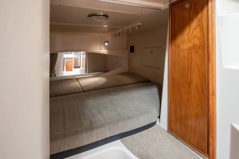 Slide: The Image of Interior cabin of 2006 Grady-White Express 360, featuring cozy bedding and wooden accents. - 31