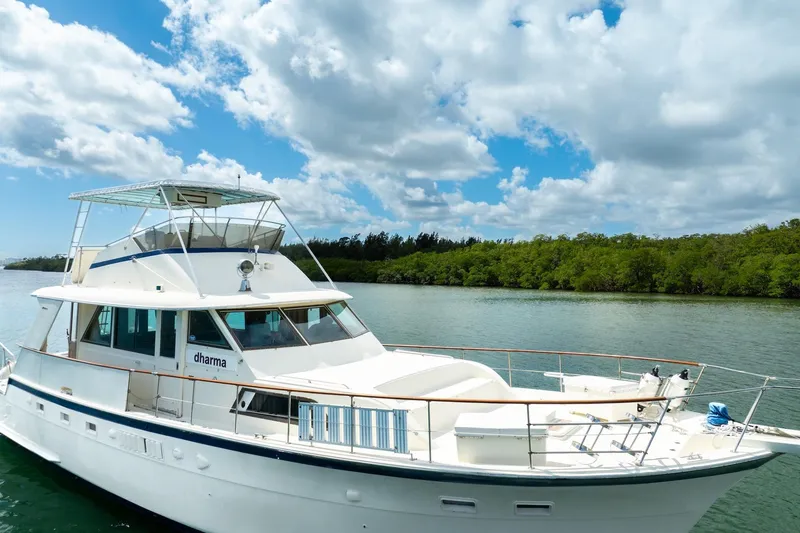 Slide: The Image of 1978 Hatteras 53 Yacht Fisherman on serene water under a partly cloudy sky. - 13