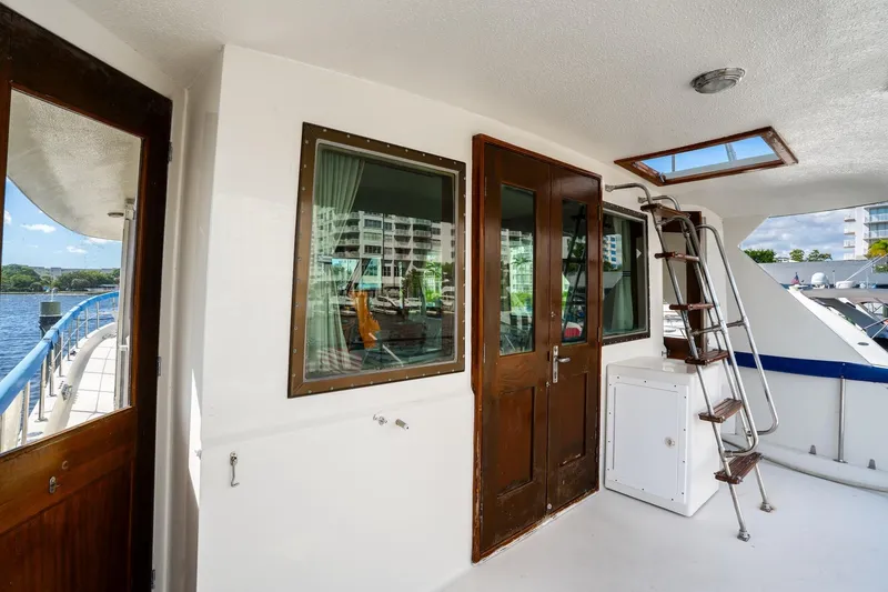 Slide: The Image of 1978 Hatteras 53 Yacht Fisherman deck with wooden doors and ladder, overlooking marina. - 31