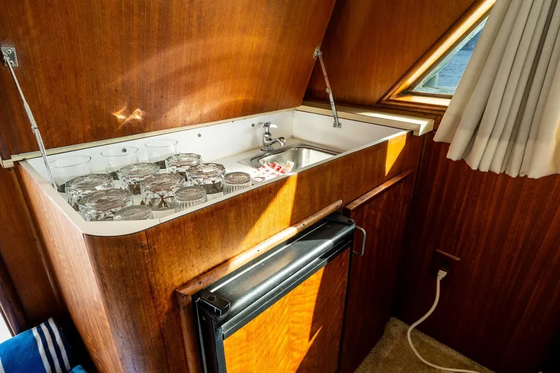 Slide: The Image of 1978 Hatteras 53 Yacht Fisherman interior with sink, glasses, and wooden cabinetry. - 48