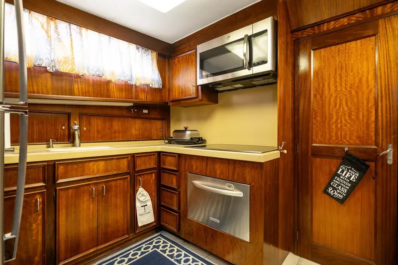 Slide: The Image of 1978 Hatteras 53 Yacht Fisherman kitchen with wood cabinetry and modern appliances. - 53