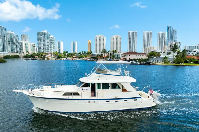 Slide: The Image of 1978 Hatteras 53 Yacht Fisherman cruising in a scenic urban waterfront setting. - 6