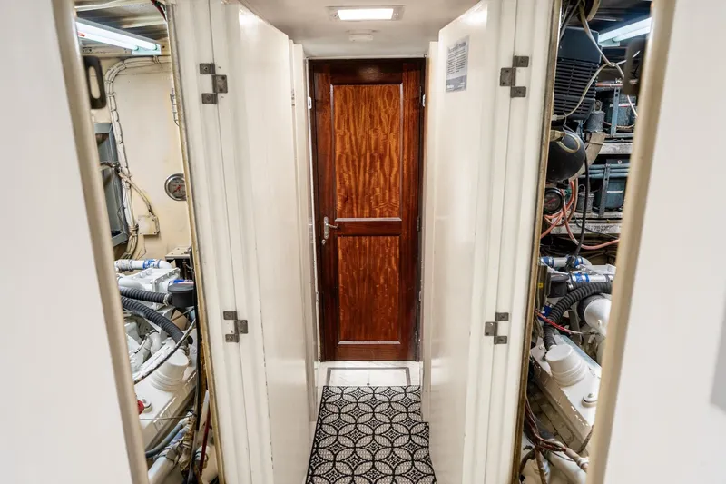 Slide: The Image of Engine room corridor of a 1978 Hatteras 53 Yacht Fisherman, featuring a wooden door. - 63