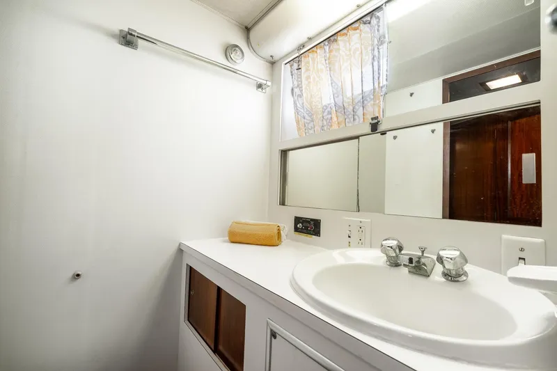 Slide: The Image of 1978 Hatteras 53 Yacht Fisherman bathroom with sink, mirror, and towel. - 71