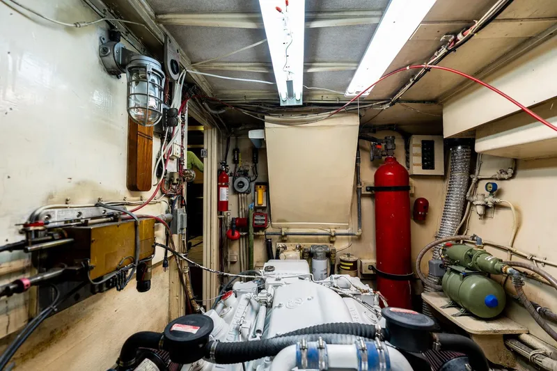 Slide: The Image of Engine room of a 1978 Hatteras 53 Yacht Fisherman, featuring mechanical equipment and wiring. - 78