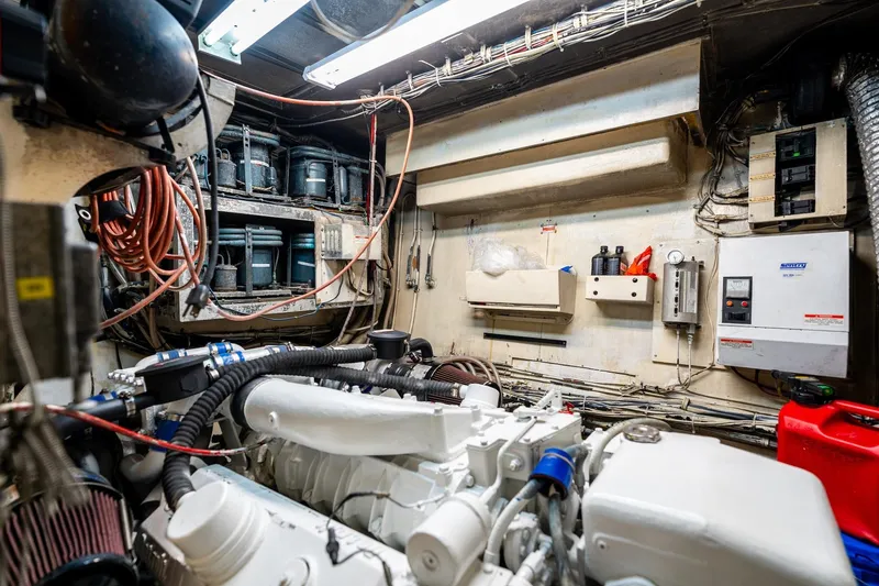 Slide: The Image of Engine room of a 1978 Hatteras 53 Yacht Fisherman, showcasing mechanical components and wiring. - 83