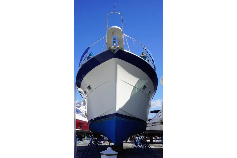 Slide: The Image of 1978 Hatteras 53 Yacht Fisherman on dry dock under clear blue sky. - 88