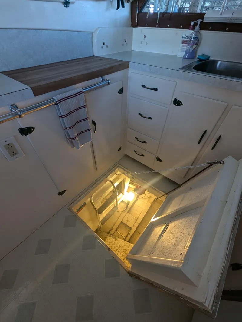 Slide: The Image of Pacemaker 53 Motor Yacht 1965 kitchen with open floor hatch revealing stairs. - 23