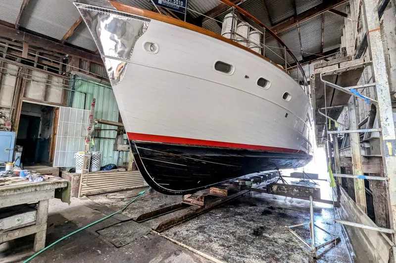 Slide: The Image of 1965 Pacemaker 53 Motor Yacht in dry dock, showcasing its sleek hull design. - 30