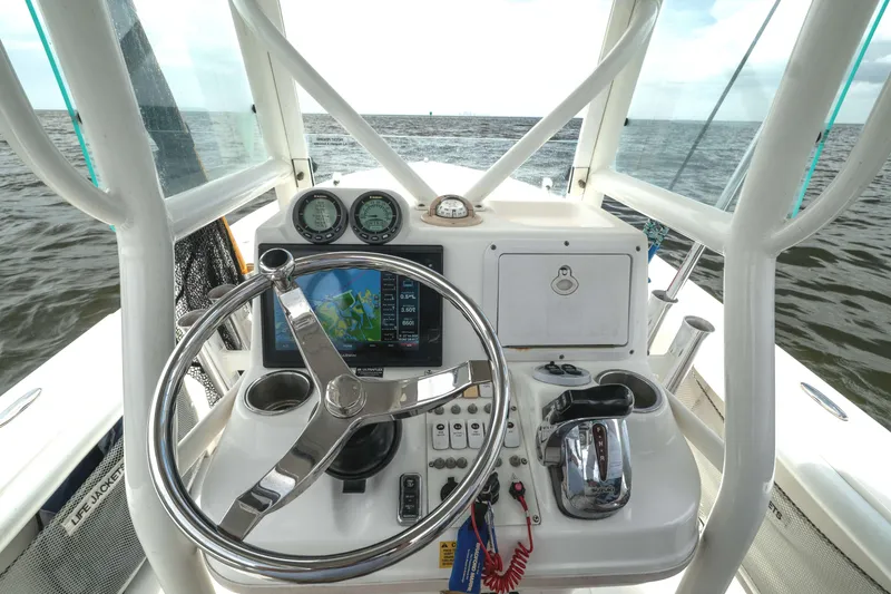 Slide: The Image of 2007 Everglades 243 Center Console boat dashboard with steering wheel and navigation instruments. - 19