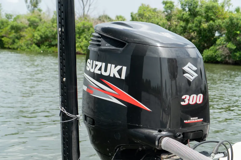 Slide: The Image of Suzuki 300 outboard motor on 2007 Everglades 243 Center Console boat, near lush shoreline. - 38