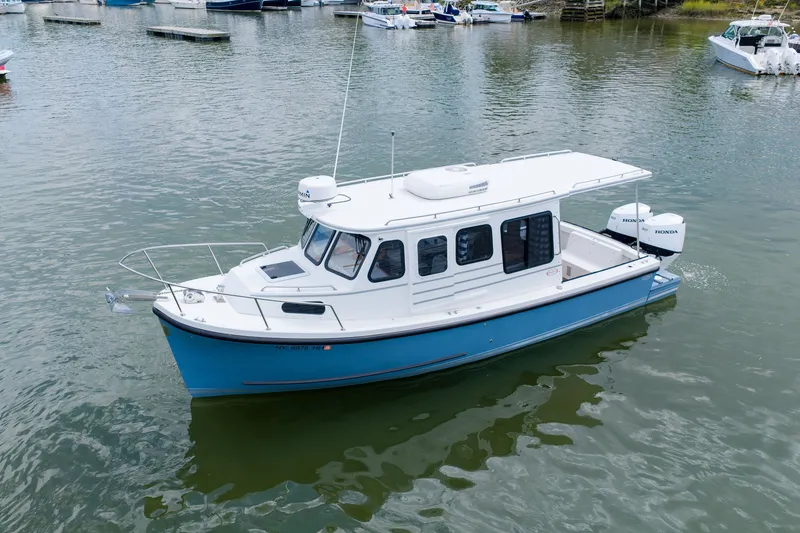 Slide: The Image of 2023 Rosborough RF-246 Halifax boat on calm water, featuring a sleek blue and white design. - 2