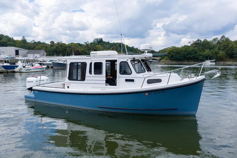 The Image of 2023 Rosborough RF-246 Halifax boat on calm water, surrounded by greenery and other boats. - 0