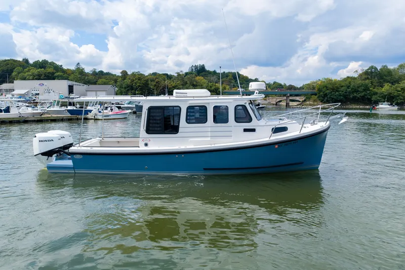Slide: The Image of 2023 Rosborough RF-246 Halifax boat on calm water, featuring a blue hull and Honda outboard motor. - 3