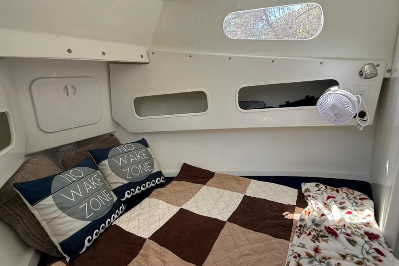Slide: The Image of Cozy cabin interior of 2023 Rosborough 246 Halifax boat with pillows and quilted bedding. - 30
