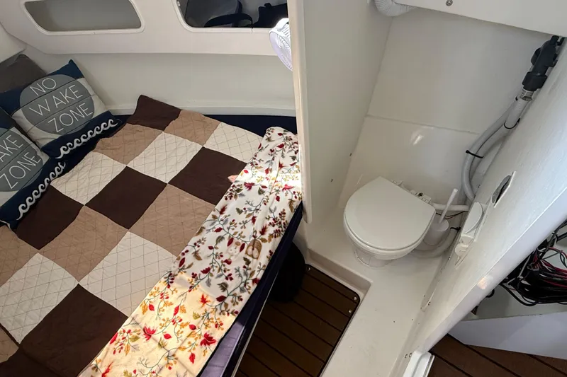 Slide: The Image of 2023 Rosborough 246 Halifax cabin interior with bed, pillows, and compact bathroom. - 32