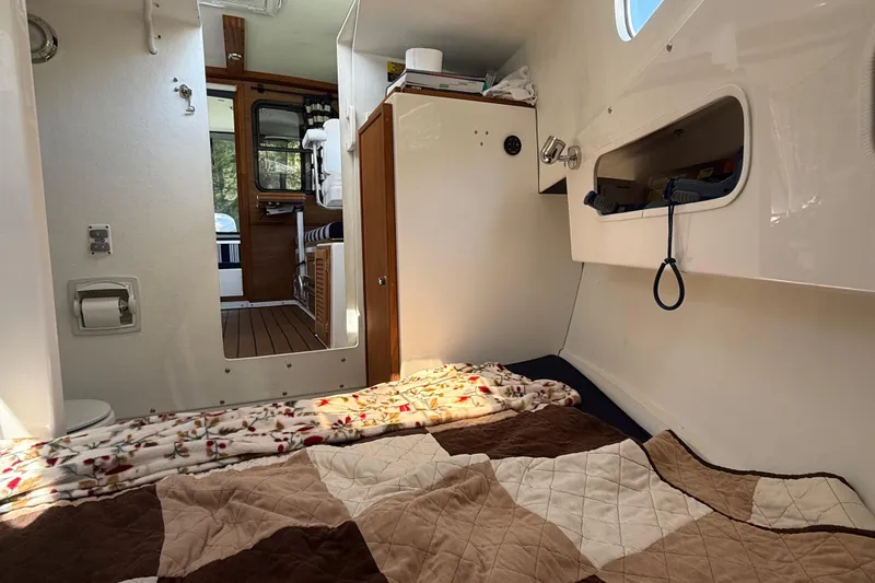 Slide: The Image of Interior of 2023 Rosborough 246 Halifax boat, featuring cozy sleeping area and wooden accents. - 31