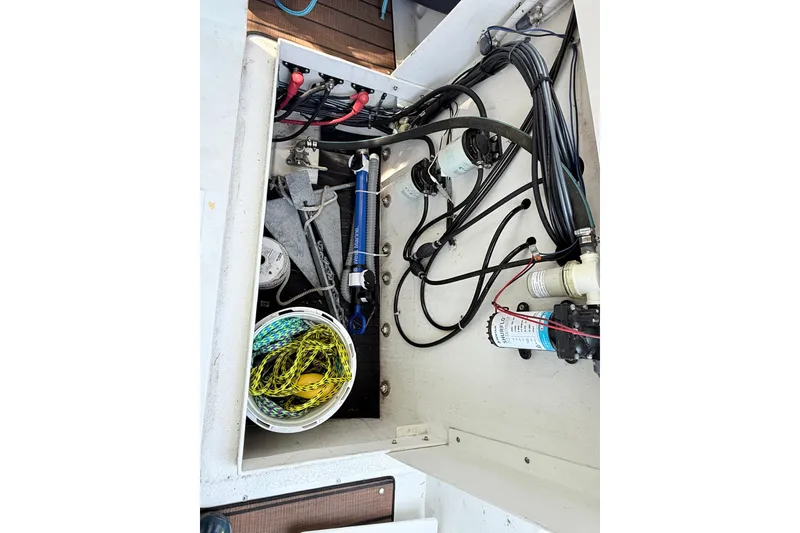 Slide: The Image of 2023 Rosborough 246 Halifax boat compartment with wiring, pumps, and storage bucket. - 74