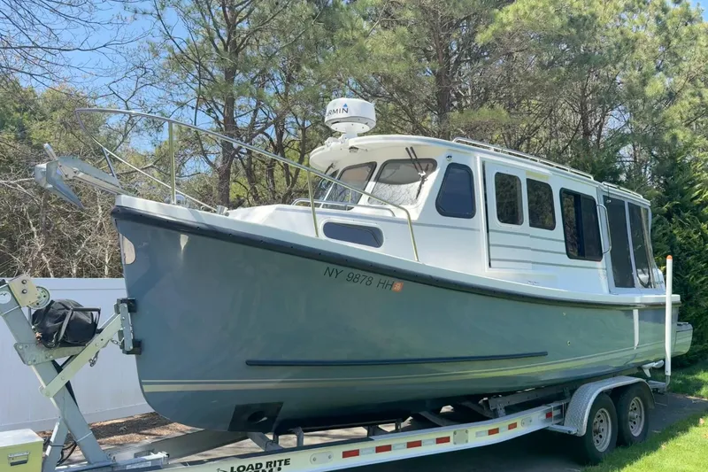 Slide: The Image of 2023 Rosborough 246 Halifax boat on trailer, surrounded by trees. - 6