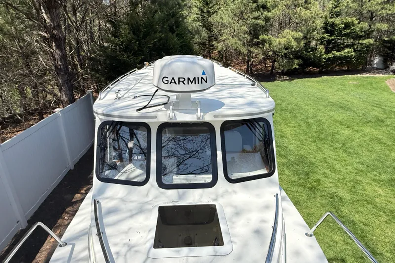 Slide: The Image of 2023 Rosborough 246 Halifax boat with Garmin radar, parked on grass near trees. - 38