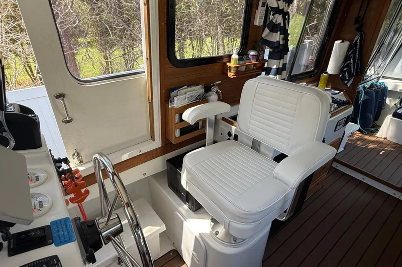 Slide: The Image of Interior of 2023 Rosborough 246 Halifax boat with white captain's chair and wooden accents. - 23