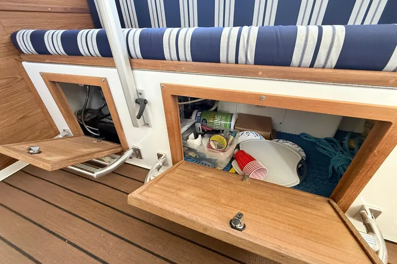 Slide: The Image of 2023 Rosborough 246 Halifax boat interior storage compartments with striped cushions and wooden finish. - 76