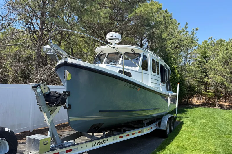 Slide: The Image of 2023 Rosborough 246 Halifax boat on trailer, surrounded by trees and grass. - 67